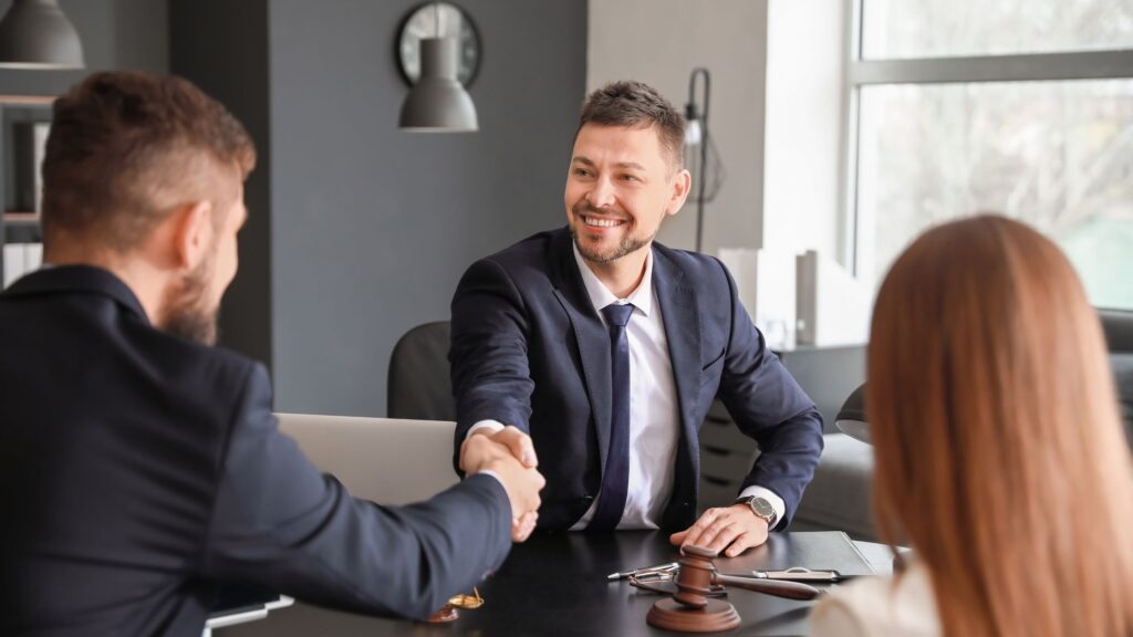 Mississippi personal injury lawyer confidently shaking hands with clients, symbolizing trust and assurance in legal representation for injury cases in Mississippi.